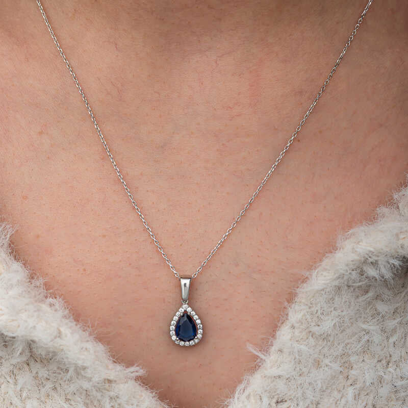 Elegant halskæde med dråbeformet blå safir i sterlingsølv med halo-design